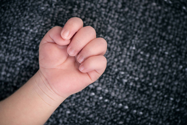 closeup tiny hand of newborn baby against blanket, shallow depth of field - Foto, Imagem