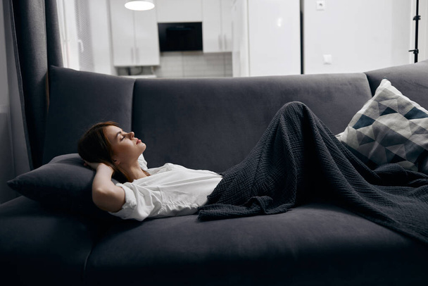 mujer se encuentra en el sofá y almohada interior suave - Foto, imagen