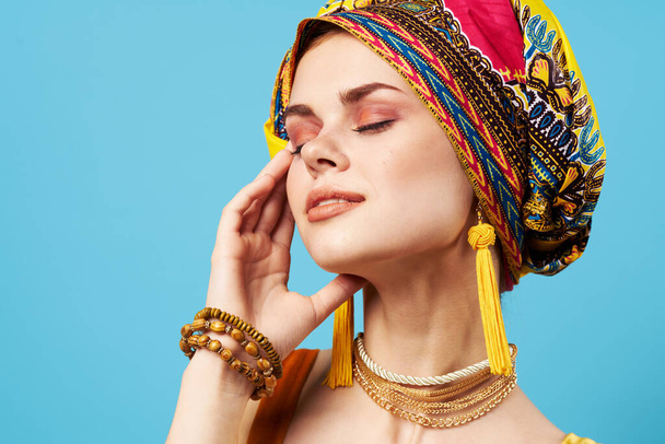 attrayant femme lumineux maquillage décoration ethnie multicolore turban studio fond bleu - Photo, image