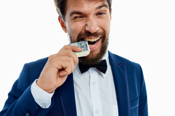bohatý gentleman v modré bundě motýlek košile peníze balení měny - Fotografie, Obrázek