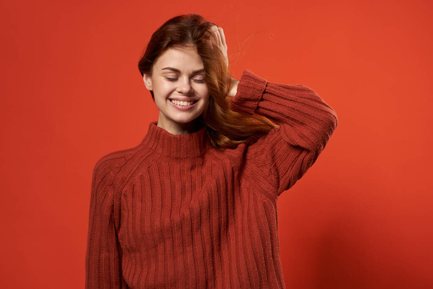 весела жінка в жовтому светрі зачіска моди посмішка випадковий одяг студія червоний фон
 - Фото, зображення
