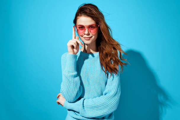 emotional woman with glasses and blue sweater lifestyle casual wear blue background - Photo, Image