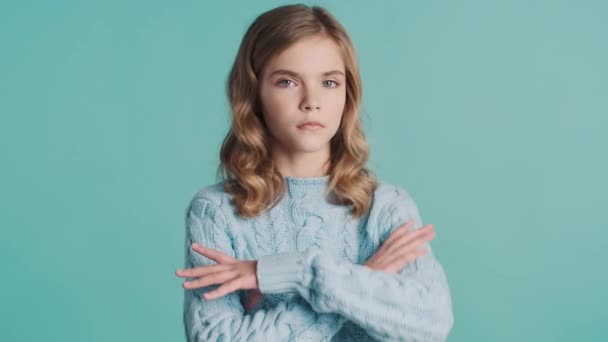 Ernstig blond tiener meisje houden armen gevouwen beledigd door het horen van slecht nieuws kijken boos op camera over kleurrijke achtergrond - Video