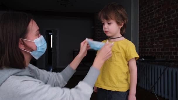 Parent met un masque protecteur sur l'enfant - Séquence, vidéo