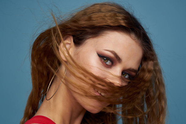 Привлекательная женщина волнистые волосы очаровательный вид косметики элегантный стиль синий фон - Фото, изображение