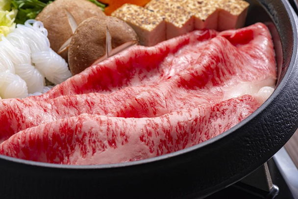 вкусное японское горячее блюдо, приготовленное из свежей говядины - Фото, изображение
