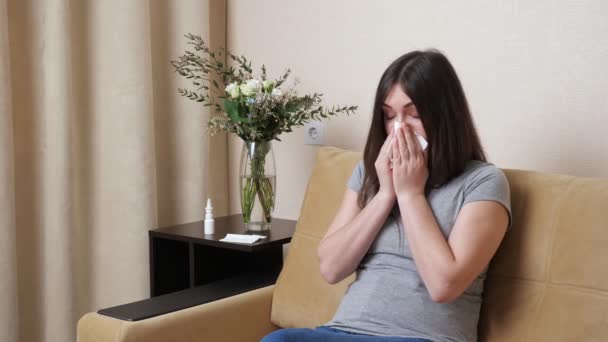 Long haired brunette smells flowers sneezes and sprays nose - Footage, Video