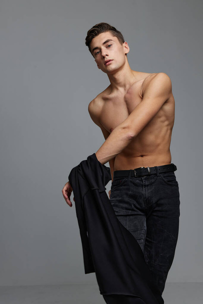 Nice man with a topless black jacket in the hands of a glamor studio - Fotó, kép