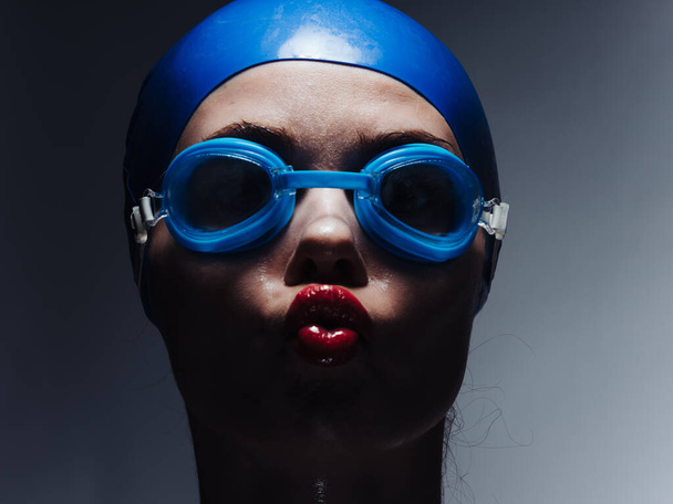 Female silhouette on a dark background goggles for swimming diving cap - Photo, Image