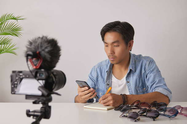 Aziatische Vlogger of Blogger met behulp van Smartphone en schrijf Customer Order en opname video. Freelancer Online live streamen met de klant via sociale media - Foto, afbeelding