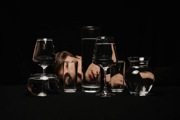portrait surréaliste d'un homme regardant à travers des verres d'eau - Photo, image