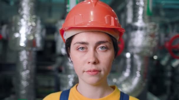 Genç bir kadın mühendisin portresi bir yapım odasında duruyor ve bakıyor. Kapatın. Yüzden uzaklaşıyorum. Modern endüstri ve üretim - Video, Çekim