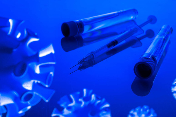 Impfflasche. Medizinische Spritze mit Nadel zum Schutz gegen Grippeviren und Coronaviren. Covid Impfstoff auf blau. Konzept: Krankheiten, medizinische Versorgung, Wissenschaft - Foto, Bild
