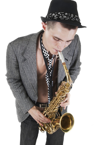 Nuori jazzmies soittaa saksofonia.
 - Valokuva, kuva