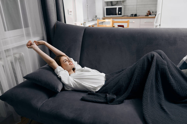 onnellinen nainen, jolla on kohotetut kädet, on sohvalla - Valokuva, kuva