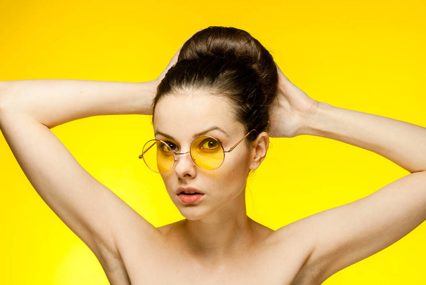 donna allegra spalle nude occhiali gialli radunati capelli Studio - Foto, immagini