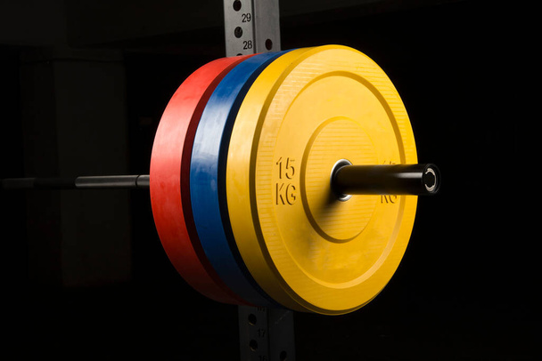 Barbell bar and barbell plate on black background - Photo, Image