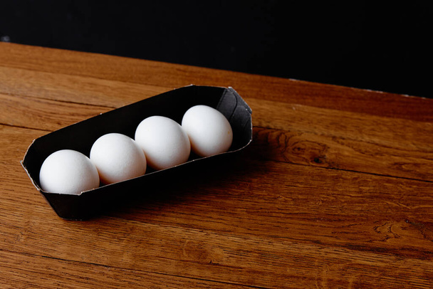 άσπρα αυγά κοτόπουλου σε ένα δίσκο σε ένα ξύλινο τραπέζι φυσικό προϊόν - Φωτογραφία, εικόνα