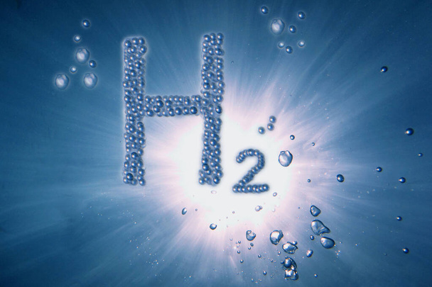azul hidrógeno h2 letras con un montón de pequeñas burbujas en un agua azul con rayos de sol - Foto, Imagen