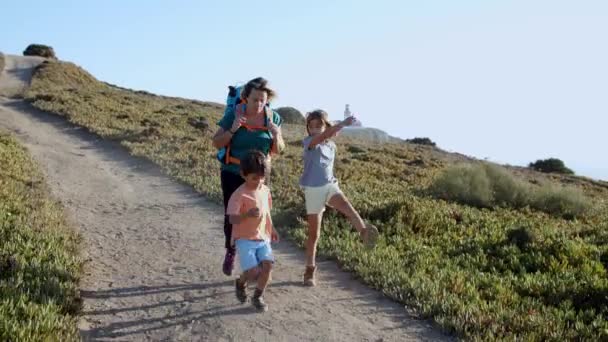 Счастливые активные дети ходят и прыгают по горной тропе - Кадры, видео