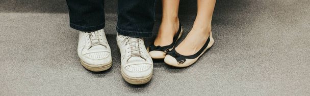 Close-up van man en vrouw benen in outdoor schoenen samen. Een paar afspraakjes samen. Liefde en romantiek. Romantisch daten. Details en lichaamsdelen. Koptekst webbanner. - Foto, afbeelding