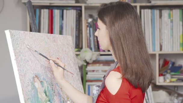 Piękna młoda kobieta maluje obraz na warsztatach plastycznych - Zdjęcie, obraz