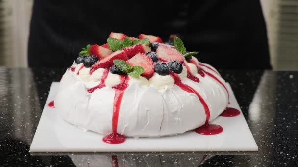 El chef de pastelería espolvorea azúcar en polvo en la torta Anna Pavlovas. - Metraje, vídeo