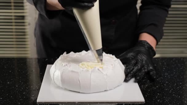 Konditor füllt Sahne-Brownies mit Teigtasche. Prozess der Herstellung von Kuchen Anna Pavlova. - Filmmaterial, Video