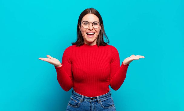 young pretty casual woman feeling happy, excited, surprised or shocked, smiling and astonished at something unbelievable - Foto, Imagen