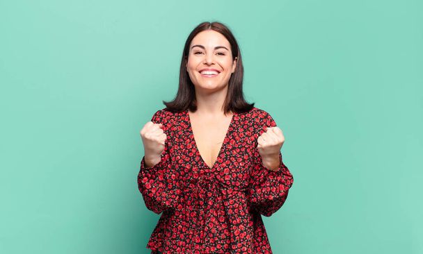 young pretty casual woman shouting triumphantly, laughing and feeling happy and excited while celebrating success - Photo, Image