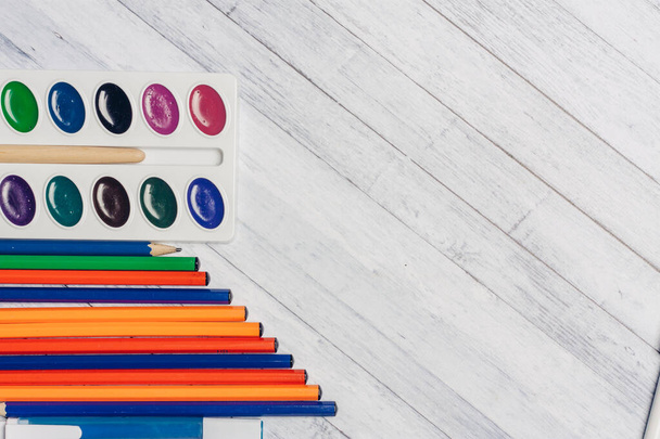 πολύχρωμα μολύβια και ακουαρέλες με πινέλο σε ξύλινο φόντο Αντιγραφή χώρου - Φωτογραφία, εικόνα
