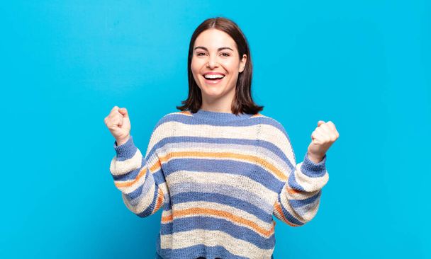 young pretty casual woman feeling happy, surprised and proud, shouting and celebrating success with a big smile - Fotoğraf, Görsel