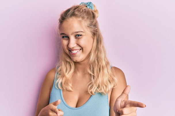 Young blonde girl wearing casual clothes pointing fingers to camera with happy and funny face. good energy and vibes.  - Valokuva, kuva