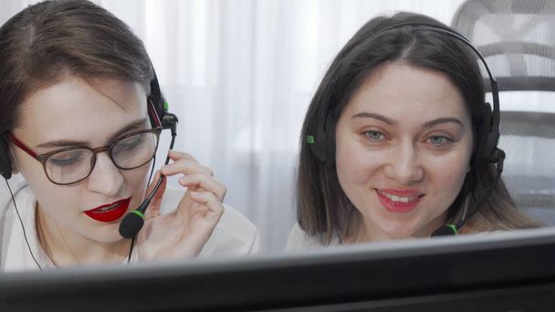 Imagen recortada de dos operadoras de call center femeninas con auriculares usando computadora - Foto, imagen