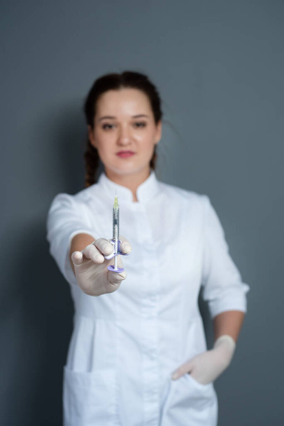 fiatal nő orvos kezében fecskendő sztetoszkóppal - Fotó, kép