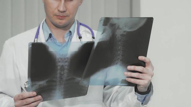 Καλλιεργημένη φωτογραφία γιατρού που εξετάζει ακτινογραφίες ασθενούς - Φωτογραφία, εικόνα