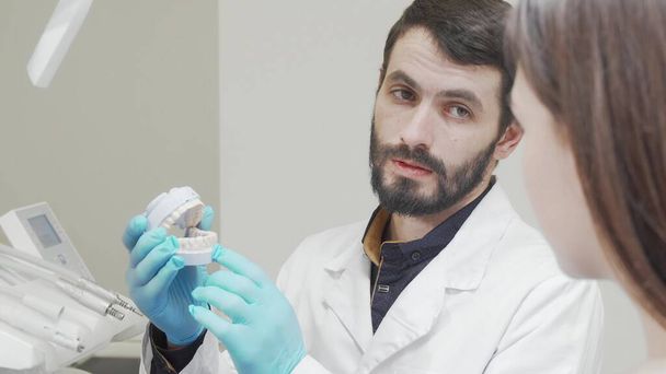 Schnappschuss eines professionellen Zahnarztes, der seinem Patienten Schimmel an den Zähnen zeigt - Foto, Bild