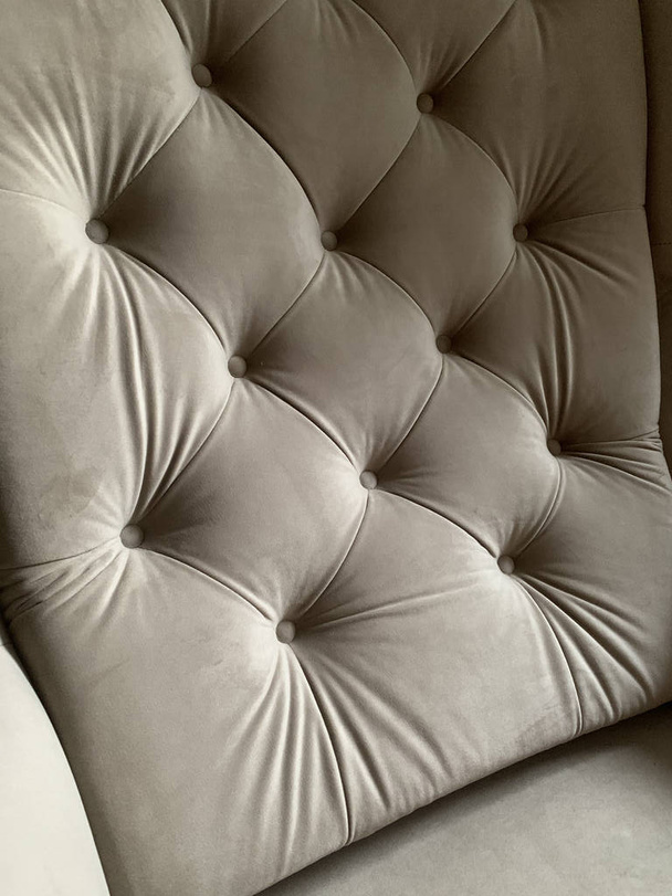 respaldo de sillón beige, sillón tapizado beige, tapicería en el sillón, tapicería de tela, tela de terciopelo, botones, sillón suave - Foto, imagen
