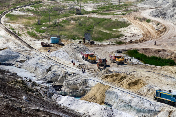 La locomotiva diesel trasporta i prodotti estratti nella cava di argilla in autocarri ribaltabili. Regione di Zaporozhye, Ucraina. maggio 2017 - Foto, immagini
