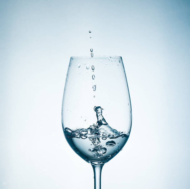 Čirá voda ve sklenici, lahodná jarní průsvitná se šplouchnutím ve skle - Fotografie, Obrázek