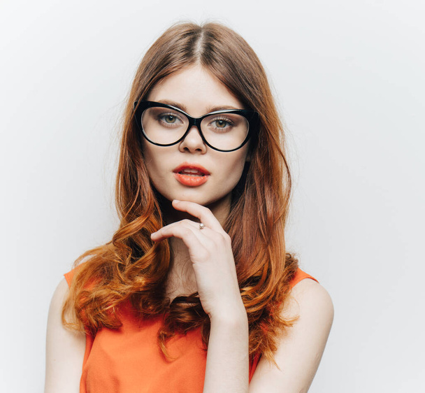 緩い髪と眼鏡とオレンジのサンドレスを持つ魅力的な女性 - 写真・画像