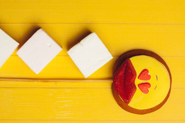caramelle sotto forma di un smiley su un bastone caramelle marmellata dolci fondo di legno giallo - Foto, immagini