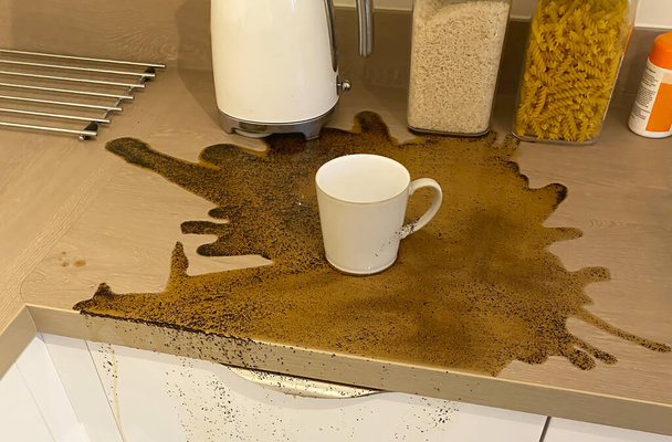 Bevanda caffè rovesciato e fagioli macinati sul piano di lavoro della cucina - Foto, immagini