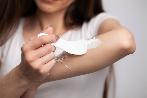 close-up vrouw brengt ontharing crème op haar hand - Foto, afbeelding