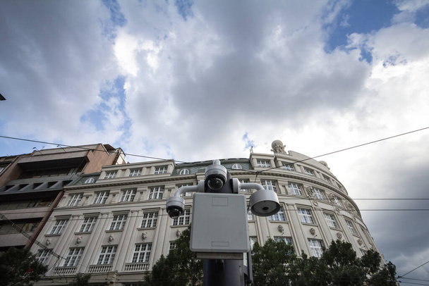Két kupola kamera alulról nézve egy régi épület előtt, egy belvárosi európai városközpontban. Ezeket a kamerákat a közterület biztonságára használják.. - Fotó, kép