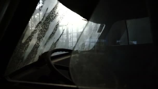 Un chico roba de una fábrica abandonada con vidrieras. Vieja furgoneta en una fábrica abandonada con vidrieras. El resplandor del sol de las vidrieras de la antigua fábrica - 4K - Metraje, vídeo