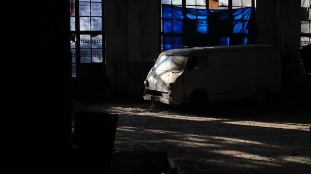 Uma carrinha velha numa fábrica abandonada com vitrais. Brilho do sol das janelas de vitrais da antiga fábrica - 4K - Filmagem, Vídeo