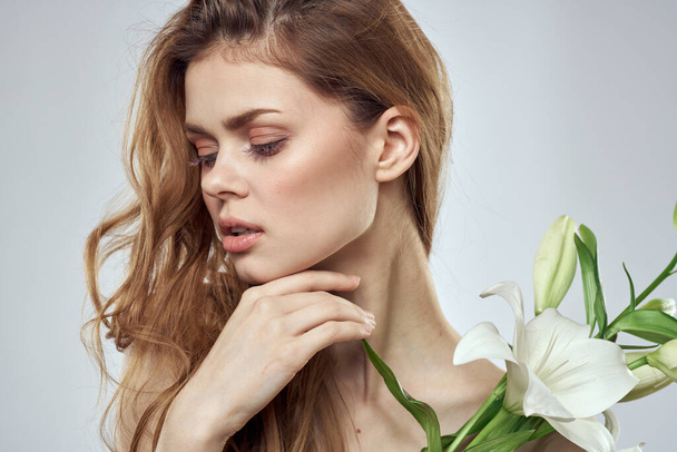 Emotional woman with flowers spring model naked shoulders clear skin - Fotografie, Obrázek