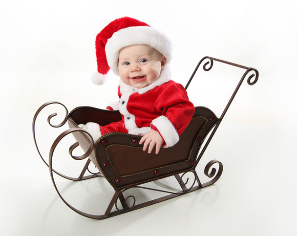 Santa bebé sentado en un trineo
 - Foto, Imagen