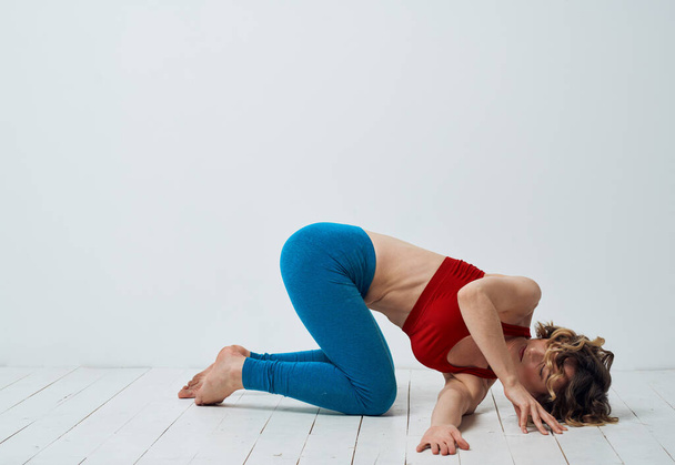 Yoga trainiert schlanke Frau blaue Leggings rotes Tank-Top - Foto, Bild